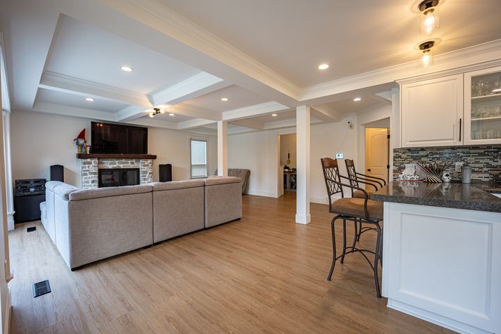 Open living room and kitchen under a coffered ceiling