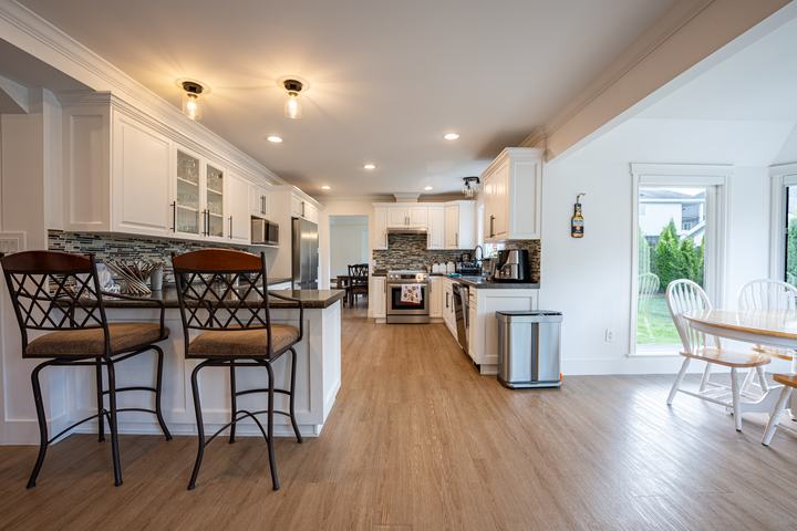 Kitchen island with bar stools and a sunny breakfast nook