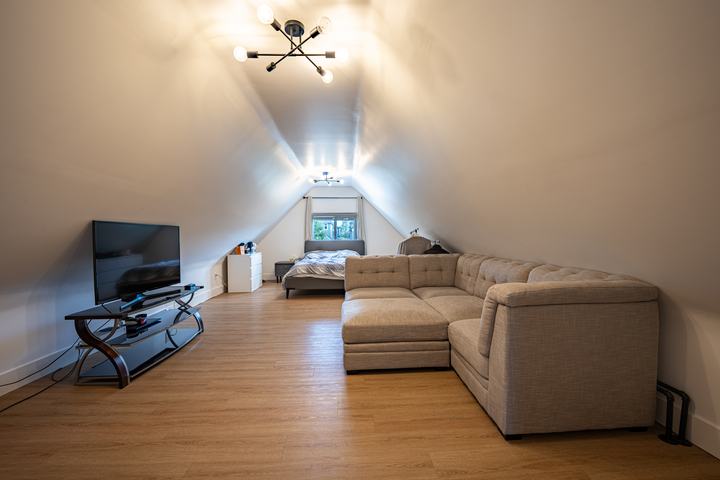 Bonus room with a vaulted ceiling and sectional sofa