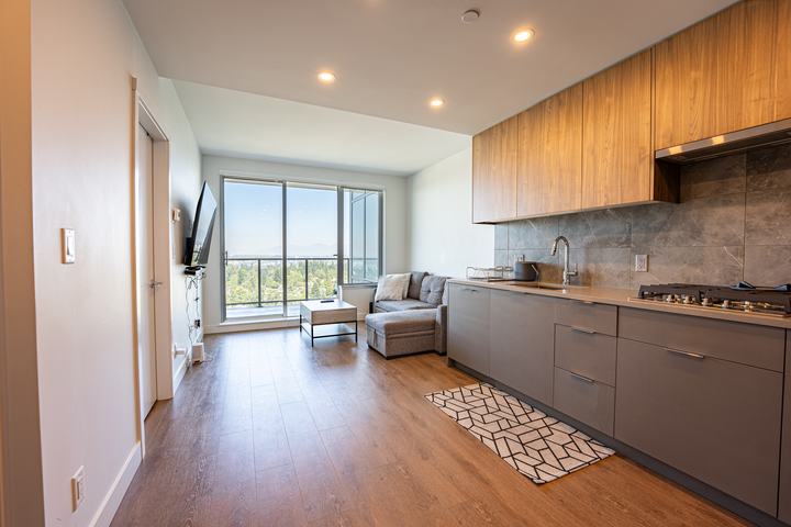 Condo kitchen and living area with floor-to-ceiling windows