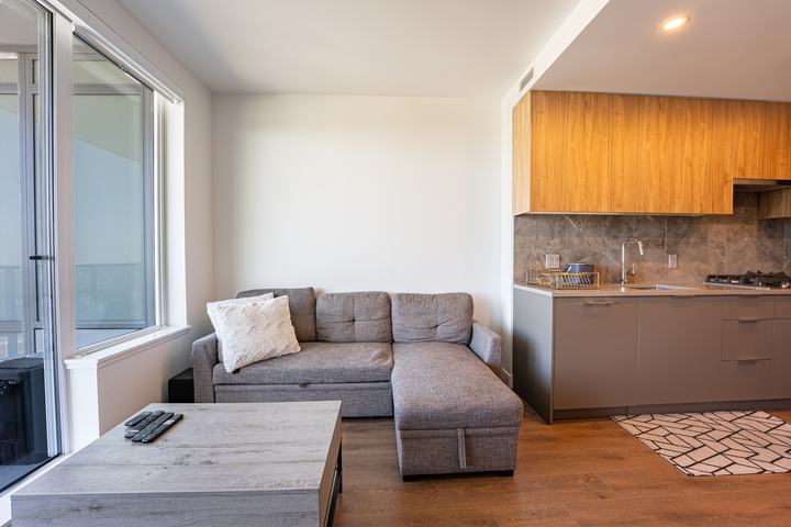 Condo living room with a sectional sofa and open kitchen