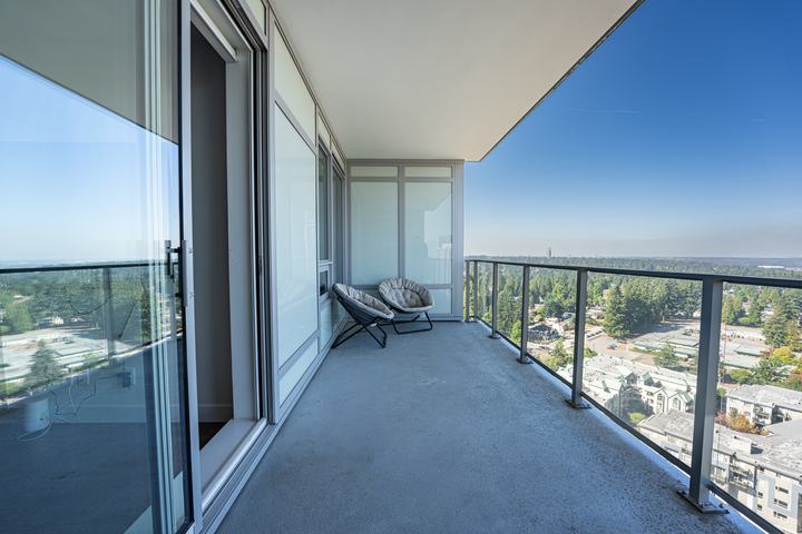 Condo balcony with glass railing and a wide city view