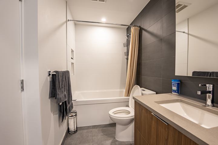 Modern condo bathroom with a deep tub and floating vanity